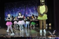 Group of girls in tutus on stage and an adult male in a costume with a tutu also on stage