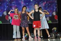 Four kids dressed in casual clothes on the stage