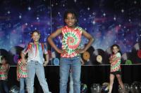 Kids in tie dye smiling on stage