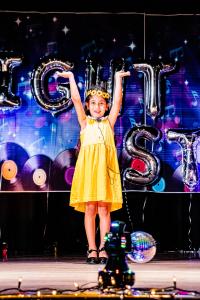 Performer in yellow with her two hands up