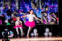 Performers wearing white shirts and pink tutus