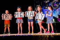 Performers holding posters with the letters DRO on the first poster, then ME, then DA, then RY on the last poster
