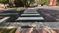 A photo of a new crosswalk, curb ramps, and pedestrian median island on Holland Lane.