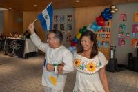 woman and man in white and yellow outfits holding a flag