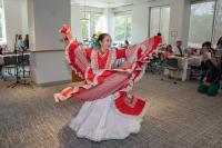 woman in red and white dress dancing in room with others watching