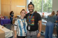 man and woman standing next to each other smiling at camera