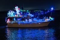 boat on the water with holiday lights and decorations