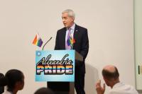 Speaker on stage with Alexandria Pride sign