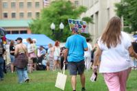 Person with "free dad hugs sign"