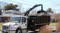City Worker operates Knuckle boom truck for bulky yard waste collection