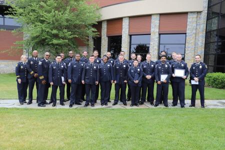 A picture of the APD graduates standing with Chief of Police and APD training staff. 