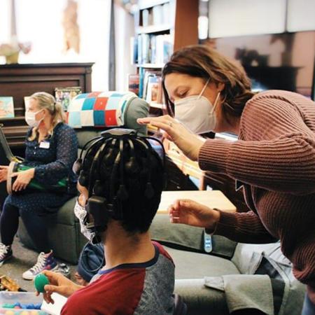 woman in mask talking to room of students