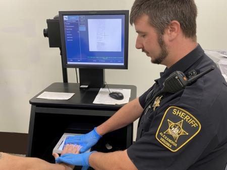 deputying using digital scanner to take fingerprints