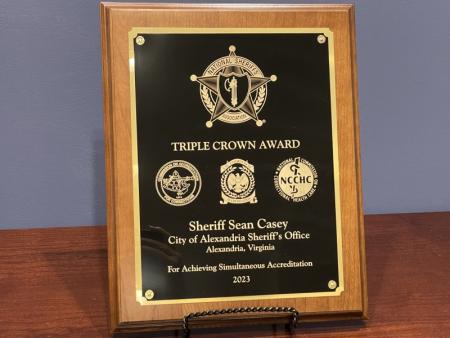 black, gold and wooden plaque from National Sheriffs' Association recognizing Alexandria Sheriff's Office with Triple Crown status
