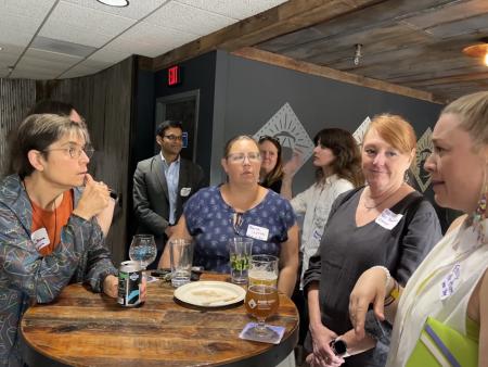 Attendees at an Eco-City Business networking event talk with each other.
