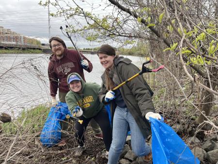 Volunteers pose with their bags and grabbers at the Four Mile Run steam cleanup.