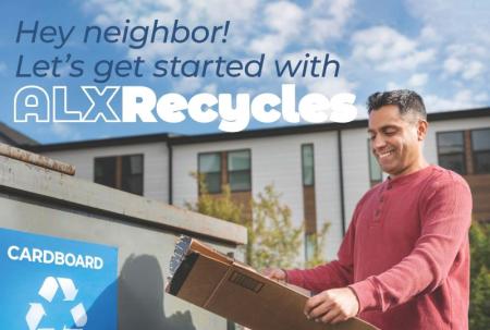 A person putting cardboard in the recycling dumpster.