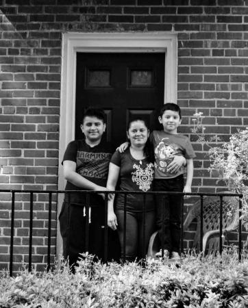 A family with two boys stands in front of a doorway at their home in Arlandria. 