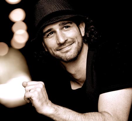 man smiling in black and white photo with hat