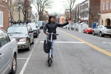 woman riding on scooter giving hand signal to turn