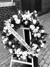 Image of a wreath with a ribbon with the words Joseph McCoy, April 23, 1897 written across it.