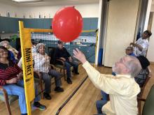 Adults playing volleyball with a balloon