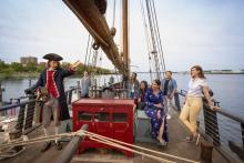 people and captain on old ship