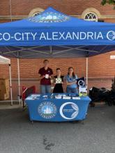 tree city employees standing under a blue tent with swag outdoors 
