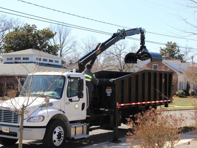 City Worker operates Knuckle boom truck for bulky yard waste collection